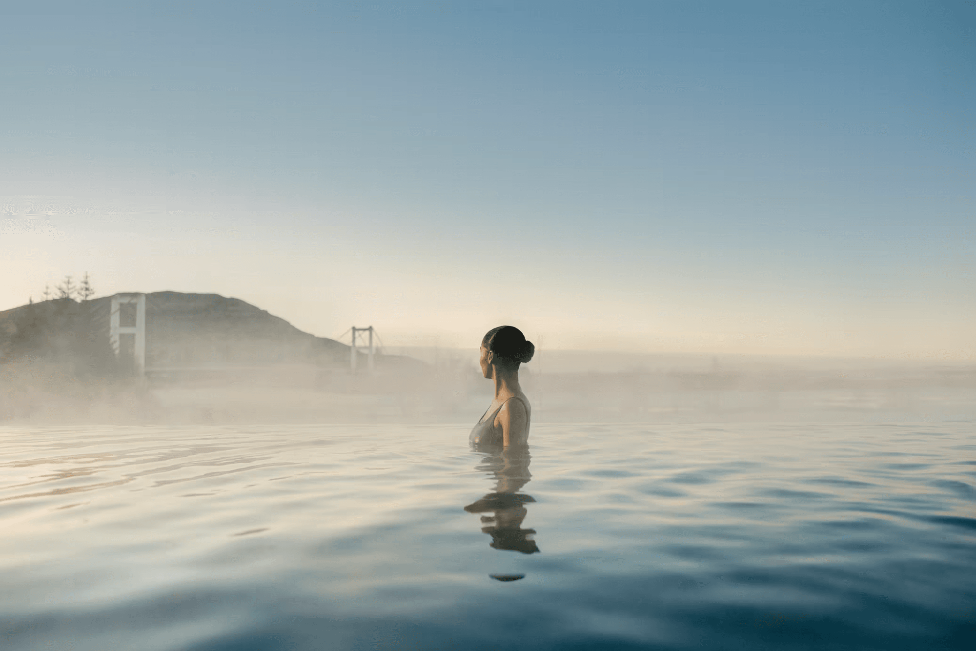 Guest enjoying the calm of the lagoon in morning mist at Laugarás Lagoon