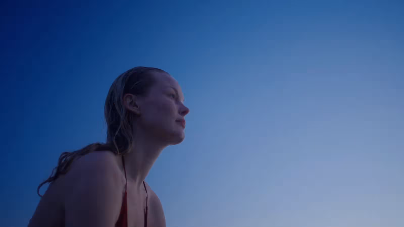 Woman in the lagoon gazing into a blue sky