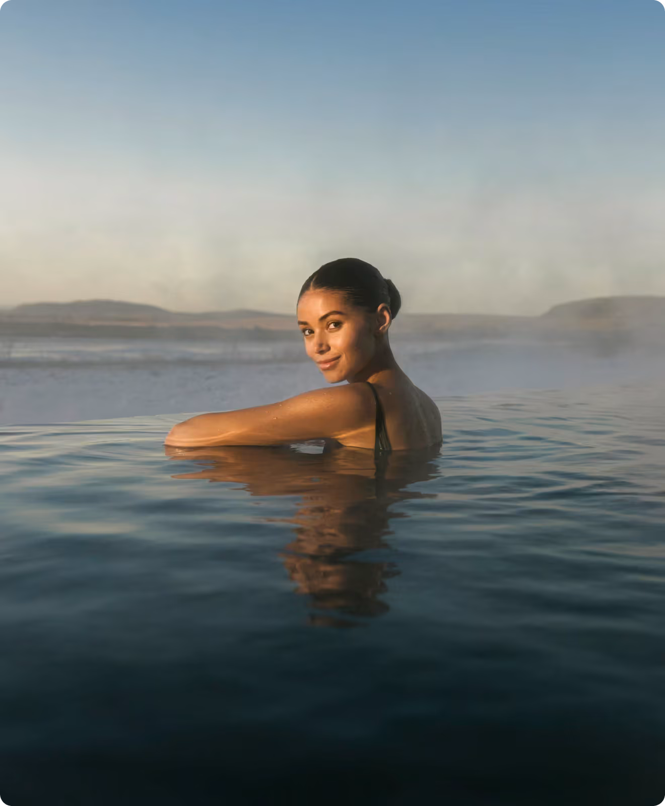 Woman smiling in the lagoon at sunset