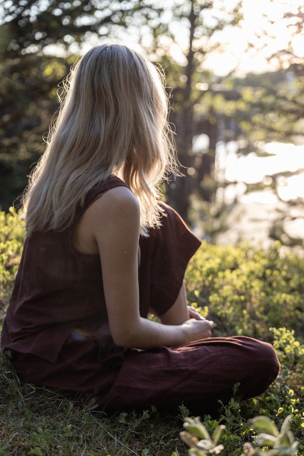 Person sitting in the forest clearing in Laugarás Lagoon