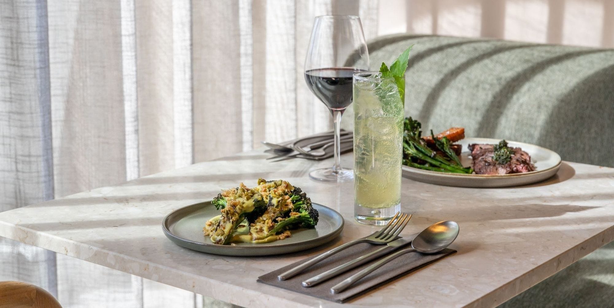 Mynd af kokteil og rauðvinsglasi ásamt broccoli rétt og Nauta skirt steik